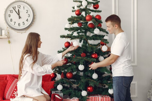 Coppia elegante a casa vicino all'albero di Natale