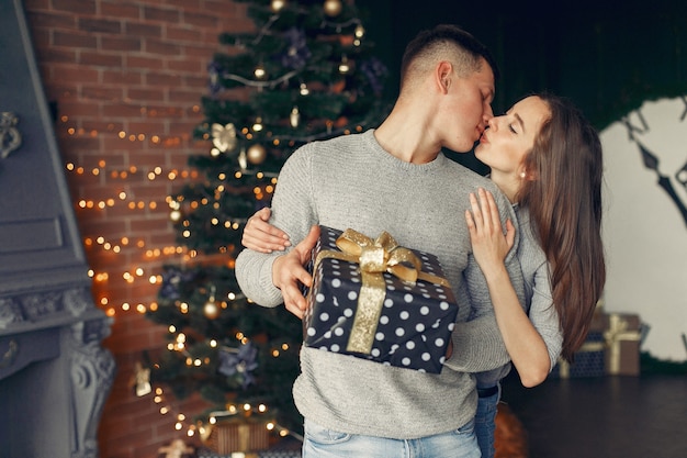 Coppia elegante a casa vicino all'albero di Natale