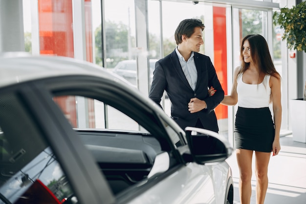 Coppia elegante e alla moda in un salone di auto