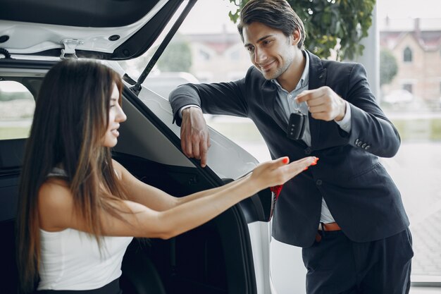 Coppia elegante e alla moda in un salone di auto