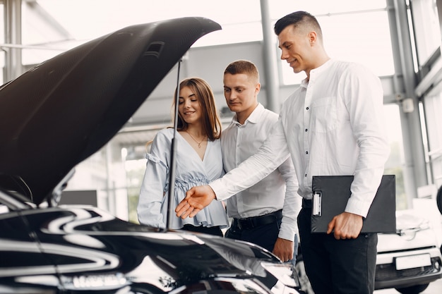 Coppia elegante e alla moda in un salone di auto