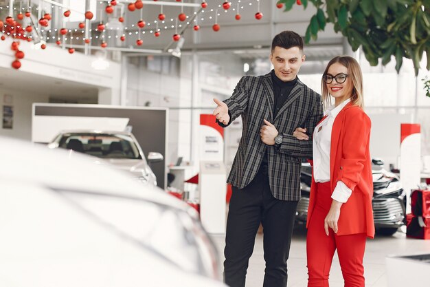 Coppia elegante e alla moda in un salone di auto