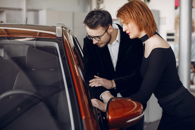 Coppia elegante ed elegante nel salone di auto