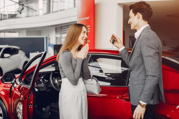 Coppia elegante in un salone di auto