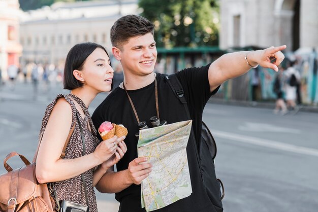 Coppia esplorando la città con mappa e gelato