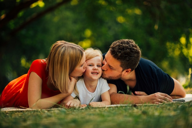 Coppia felice che bacia il loro bambino