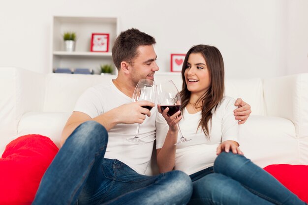 Coppia felice di trascorrere del tempo romantico con vino rosso a casa