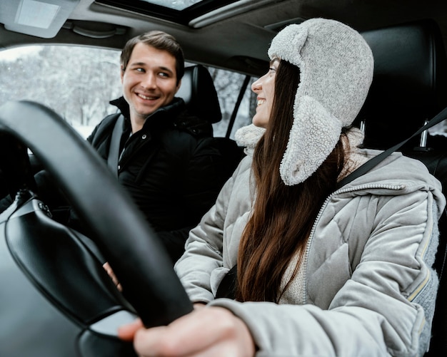 Coppia felice e sorridente insieme in macchina durante un viaggio su strada