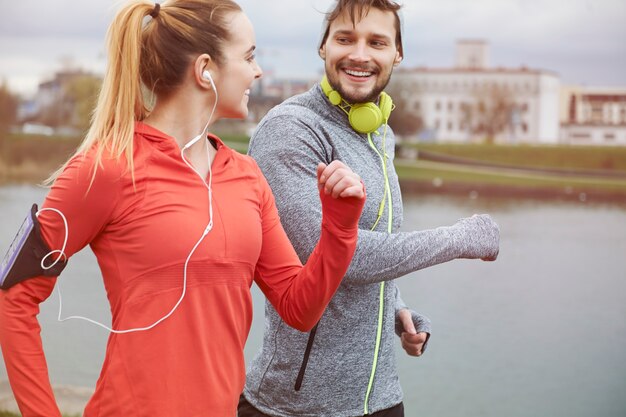 Coppia felice esercizio all'aperto. Avere un partner rende la corsa molto più facile