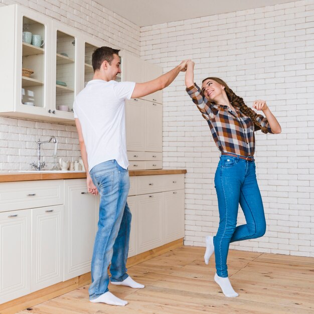Coppia felice in amore ballare in cucina