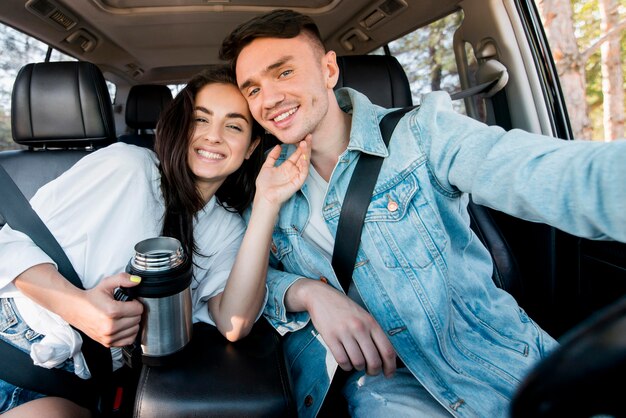 Coppia felice prendendo selfie in auto