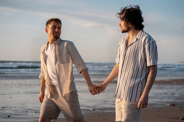 Coppia gay di tiro medio in spiaggia