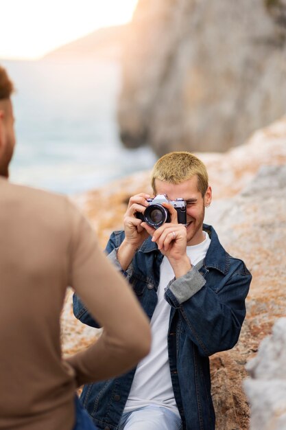 Coppia gay sulla spiaggia con la macchina fotografica