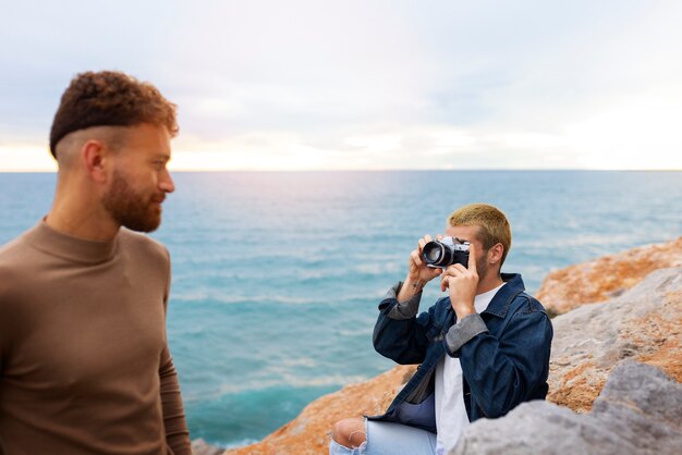 Coppia gay sulla spiaggia con la macchina fotografica