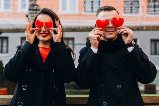 Coppia giocosa che copre gli occhi con i cuori