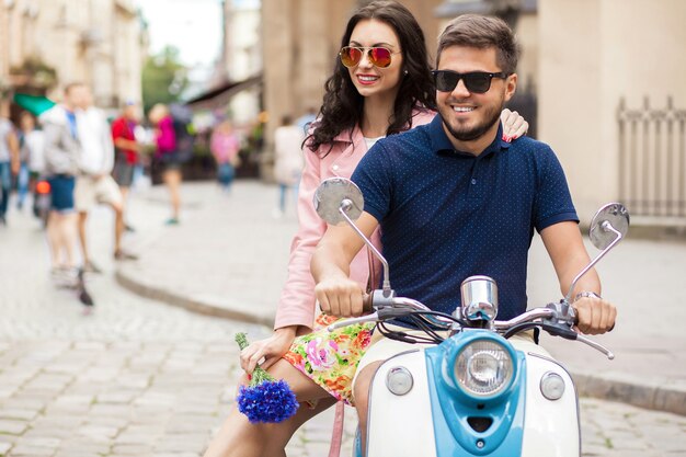 Coppia giovane bella hipster a cavallo sulla strada della città di moto