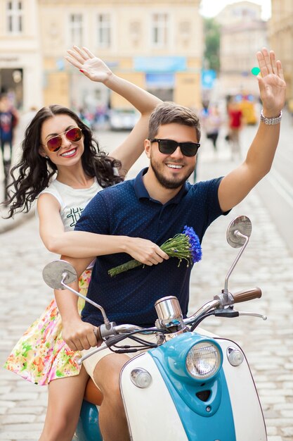 Coppia giovane bella hipster a cavallo sulla strada della città di moto