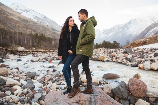 Coppia giovane bella hipster in amore, passeggiate lungo il fiume, natura selvaggia, vacanze invernali