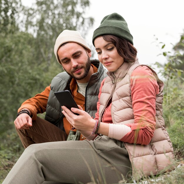 Coppia giovane guardando il telefono in natura