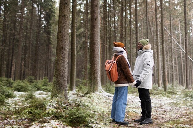 Coppia giovane in un viaggio invernale insieme a piedi attraverso la foresta