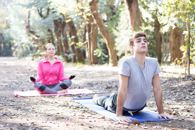 Coppia giovane riscaldamento e stretching nel parco