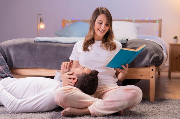 Coppia in amore leggendo in camera da letto
