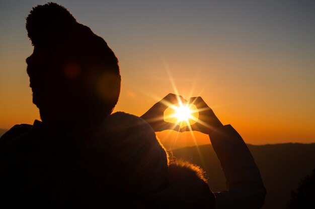 coppia in amore retroilluminazione silhouette sulla collina al momento del tramonto