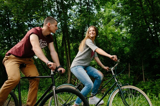 Coppia in bici Giovani coppie felici che ciclano all&#39;aperto.