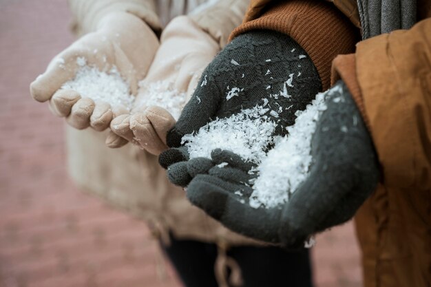 Coppia in inverno tenendo la neve nelle loro mani