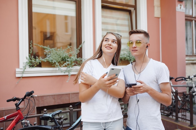 Coppia in piedi in una città con il telefono cellulare