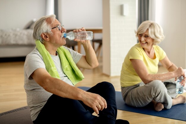 Coppia matura che ha una pausa in acqua mentre ti alleni a casa