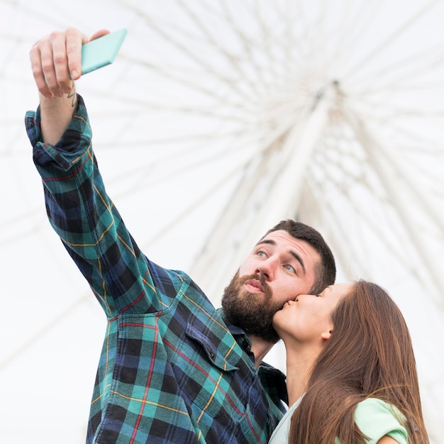 Coppia prendendo selfie mentre si bacia all'aperto