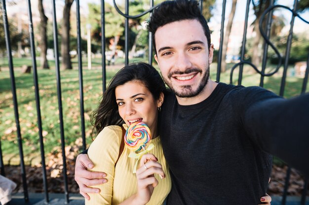 Coppia prendendo un selfie con un lecca-lecca