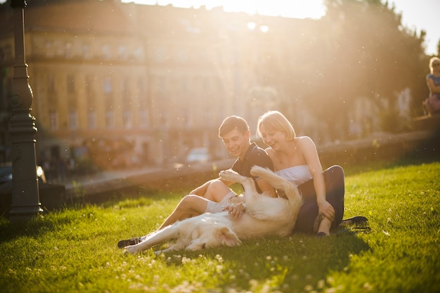 Coppia ridere con il loro cane in una giornata soleggiata