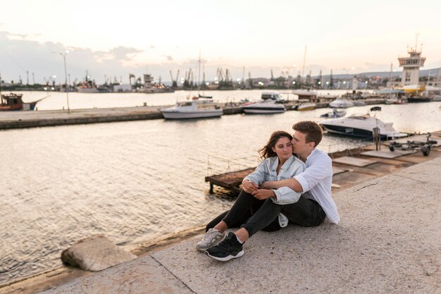 Coppia romantica abbraccia all'aperto nel porto