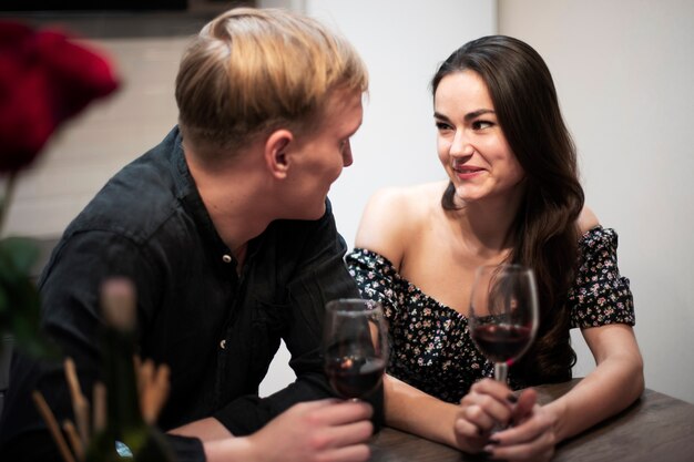 Coppia romantica che celebra il giorno di San Valentino a casa con il vino