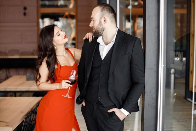 Coppia romantica in piedi nel ristorante ad un appuntamento con un bicchiere di vino