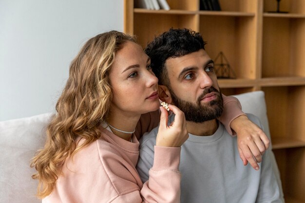 Coppia romantica mangiare popcorn e guardare film a casa