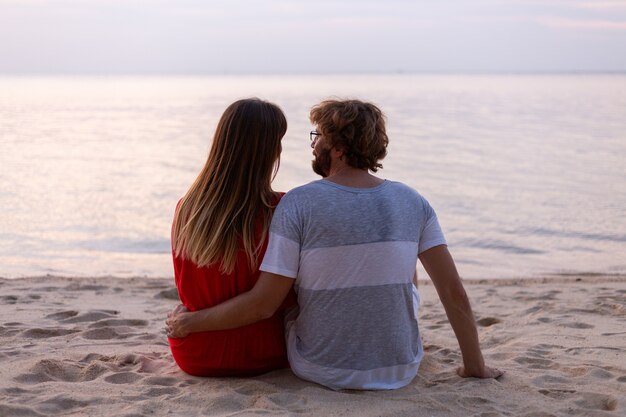 Coppia romantica sulla spiaggia al tramonto