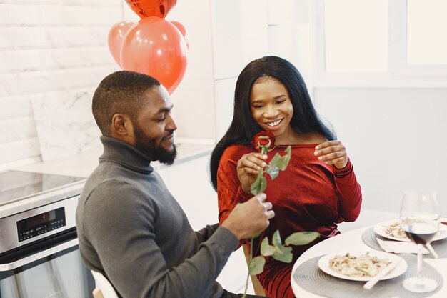 Coppia seduta a tavola, mangiare, parlare e ridere il giorno di San Valentino