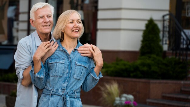 Coppia senior abbracciata che trascorre del tempo insieme in città