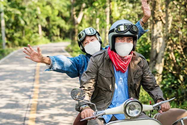 Coppia senior in sella a uno scooter nel nuovo viaggio normale