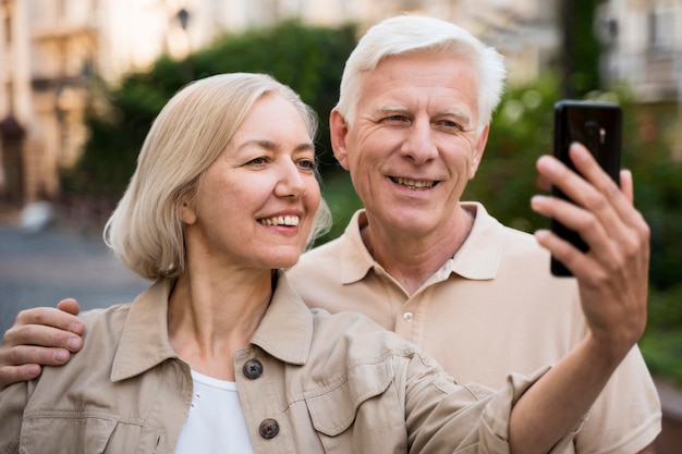 Coppia senior prendendo un selfie mentre si è fuori in città