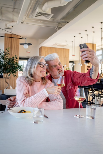 Coppia sorridente di colpo medio che prende selfie all'interno