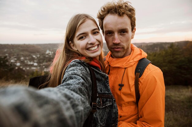 Coppia sorridente prendendo un selfie durante un viaggio insieme