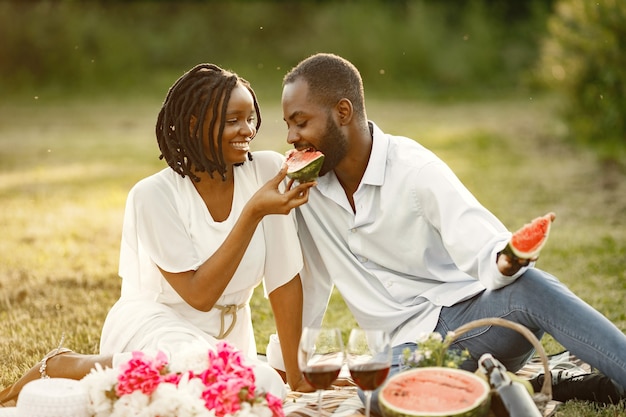 Coppia spensierata e rilassata che si gode il picnic insieme. Stanno mangiando l'anguria.