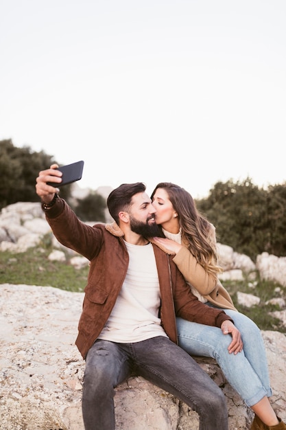 Coppia stare su una roccia e fare un selfie