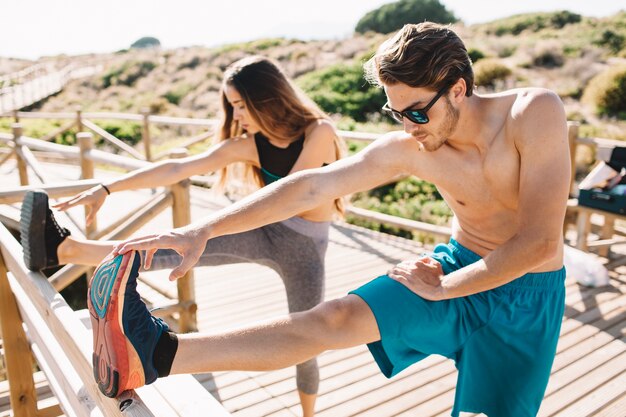 Coppia, stretching, gambe, spiaggia