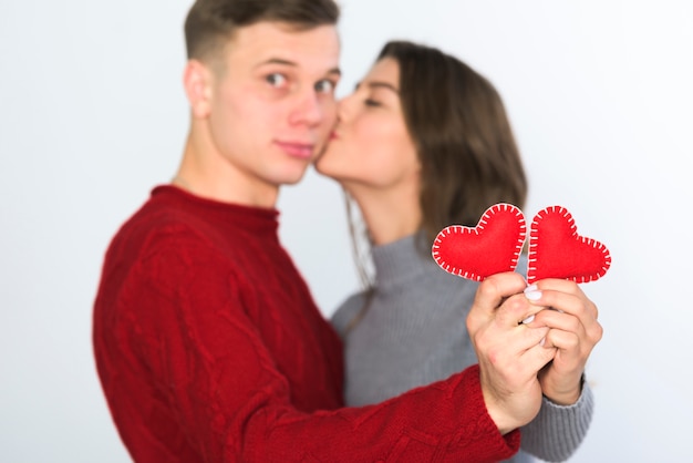 Coppia tenendo piccoli cuori morbidi nelle mani