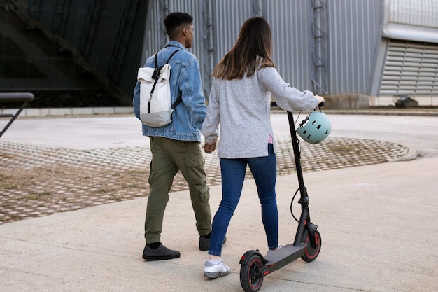 Coppia utilizzando scooter elettrico per il trasporto